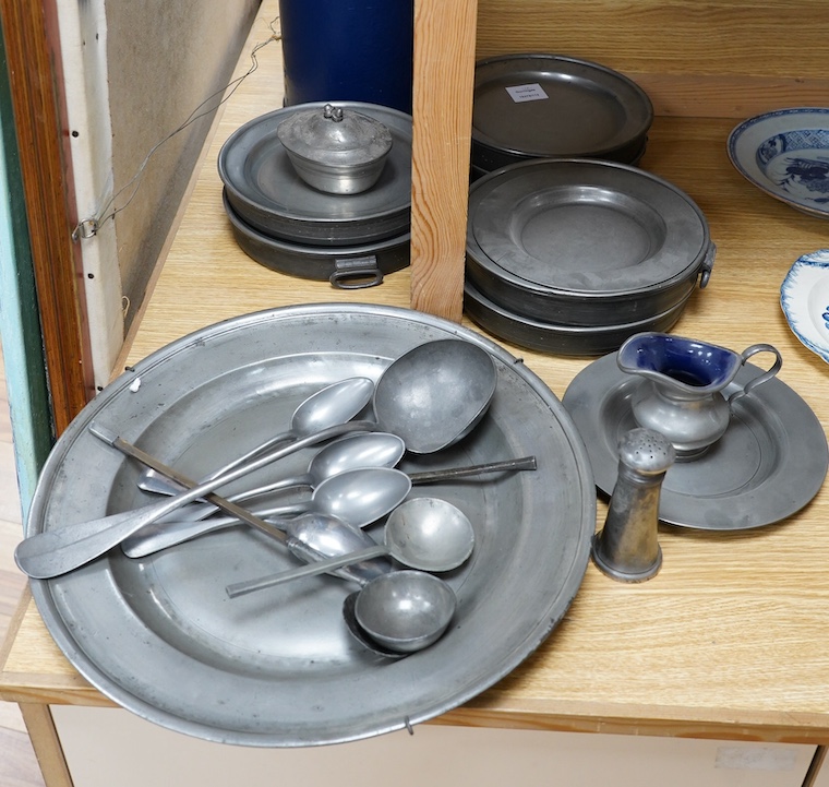 A quantity of 18th century and later pewter to include charger, warming plates and spoons, largest 39cm in diameter. Condition - mostly fair